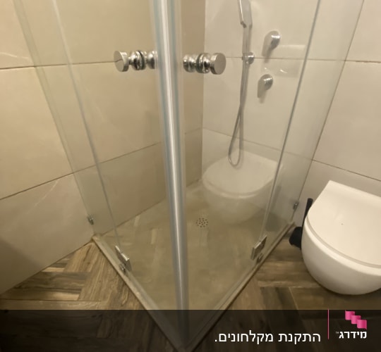 מקלחון זכוכית עם רצפת עץ וראש מקלחת